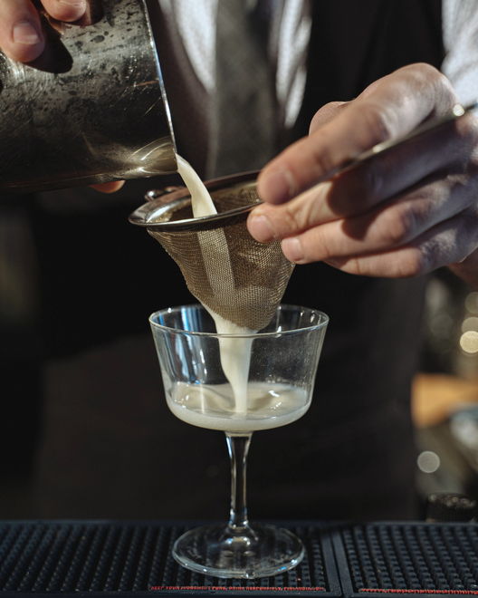 Un barman filtre un cocktail